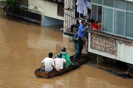 Local residents transfer to safe places on a handmade raft in the flood in Liuzhou, southwest China's Guangxi Zhuang Autonomous Region, July 4, 2009. Guilin, Hechi, Liuzhou, Laibin and Baise, cities in Guangxi Zhuang Autonomous Region, suffered the disaster of floods as torrential rains hit northwest and central Guangxi since June 30. The floods afflicted 914,500 people in Guangxi, according to the figures released on Saturday. (Xinhua/Huang Xiaobang)