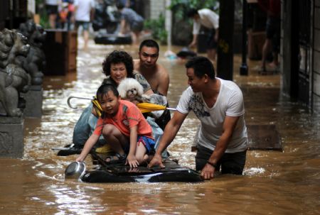 Local residents transfer to safe places on a handmade raft in the flood in Liuzhou, southwest China's Guangxi Zhuang Autonomous Region, July 4, 2009. Guilin, Hechi, Liuzhou, Laibin and Baise, cities in Guangxi Zhuang Autonomous Region, suffered the disaster of floods as torrential rains hit northwest and central Guangxi since June 30. The floods afflicted 914,500 people in Guangxi, according to the figures released on Saturday. (Xinhua/Huang Xiaobang)