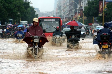 Vehicles wade through a flooded street in Nankang City, east China's Jiangxi Province, July 4, 2009. Rainstorms have swept Jiangxi since Tuesday, leaving two people dead, one missing and over 3.9 million others affected. (Xinhua/Yang Xiaoming)