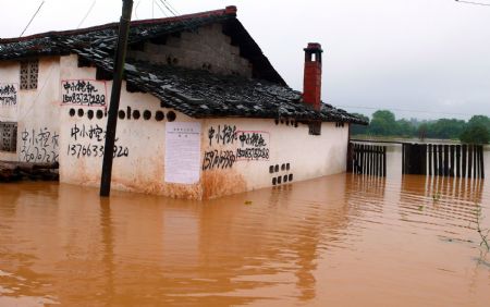 A house is submerged in water in Jingba Town of Nankang City, east China's Jiangxi Province, July 4, 2009. Rainstorms have swept Jiangxi since Tuesday, leaving two people dead, one missing and over 3.9 million others affected. (Xinhua/Yang Xiaoming)