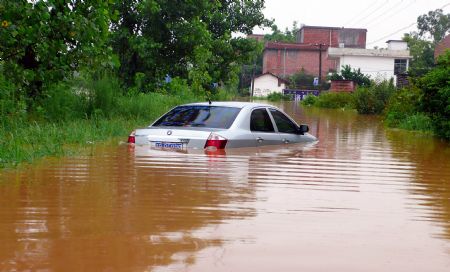 A car is submerged in water in Jingba Town of Nankang City, east China's Jiangxi Province, July 4, 2009. Rainstorms have swept Jiangxi since Tuesday, leaving two people dead, one missing and over 3.9 million others affected. (Xinhua/Yang Xiaoming)