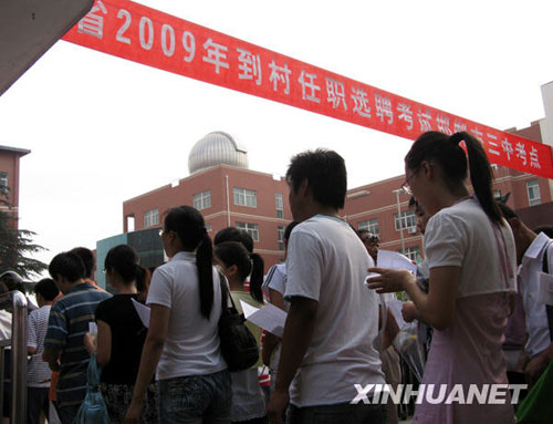 College graduates line up in front of the No. 3 middle school in Handan city, in North China's Hebei Province, to take the recruitment exam for local village government jobs on Saturday, July 4, 2009. A total of 3,000 graduates will have the chance to work as provincial village officers starting this October. [Photo: Xinhuanet] 
