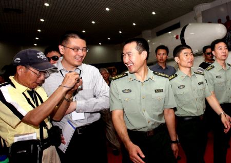 Chinese astronauts Zhai Zhigang (C), Liu Boming (2nd, R) and Jing Haipeng (1st, R) attend the exhibition 'Roaming the Universe -- Aerospace Exhibition for China