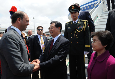 Chinese President Hu Jintao (C) is welcomed by an Italian official upon his arrival at Rome, Italy, July 5, 2009. Hu started a state visit to Italy on Sunday. Hu will also attend the outreach session of the Group of Eight (G8) summit scheduled for July 9th in the central Italian city of L'Aquila. [Xinhua]