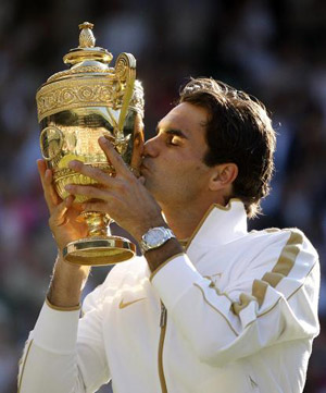 Switzerland's Roger Federer holds the Wimbledon Trophy after beating Andy Roddick of the U.S. 5-7, 7-6, 7-6, 3-6, 16-14, in the Men's Singles Final of the 2009 Wimbledon Tennis Championships at the All England Tennis Club, in southwest London, on July 5, 2009. [Xinhua]