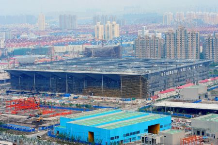 Photo taken on July 4, 2009 shows the Theme Pavilion under construction for the Shanghai 2010 World Expo in Shanghai, east China. The Shanghai 2010 World Expo is to open on May 1, 2010. [Guo Changyao/Xinhua]