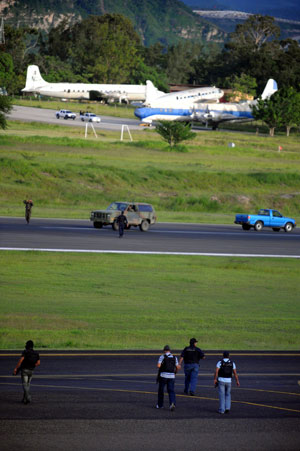 Military vehicles block the runway to prevent the landing of the Venezuelan airplane carrying ousted Honduran President Manuel Zelaya at Toncontin international airport in Tegucigalpa. The plane carrying ousted Honduran President Manuel Zelaya landed late in the Nicaraguan capital Managua, the government said here. [Xinhua/AFP]