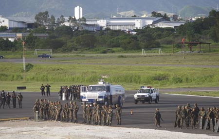 Police and soldiers block the airstrip of the Toncontin international airport to prevent the landing of a plane carrying Honduras' ousted president Manuel Zelaya in Tegucigalpa July 5, 2009. [Xinhua/Reuters]