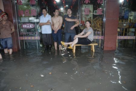 The local shoppers stray at the flooded grocery stores in downtown Yingtan city in southern China's Jiangxi province, July 4, 2009. Heavy rain and storm struck the city Saturday paralysing part of the city's communications. [Hu Nan/Xinhua]