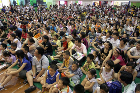 People queue up to buy ticket of a cartoon exhibition outside Shanghai East Asia Exhibition Hall in Shanghai, July 2, 2009. A cartoon exhibition was held here from July 1 to 5. (Xinhua)