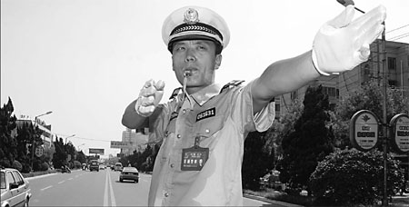 A policeman directs the traffic with his shirt soaked in sweat. [Bai Xianglin/China Daily] 