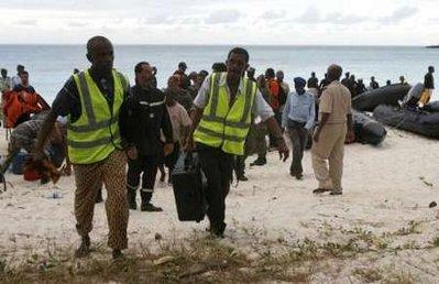 Comorian civil aviation officials carry equipment from a speed-boat after a search mission for the missing Yemenia A310-300 plane, that crashed in Mitsamiouli, 30 km (18.6 miles) north of Comores island's capital Moronoi, July 5, 2009. [Thomas Mukoya/CCTV/REUTERS] 