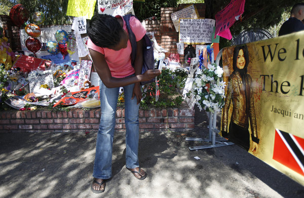 Sunday Morgan, of San Jose, Calif., photographs a makeshift memorial for pop star Michael Jackson outside the Jackson family home in the Encino section of Los Angeles, Sunday, July 5, 2009. 