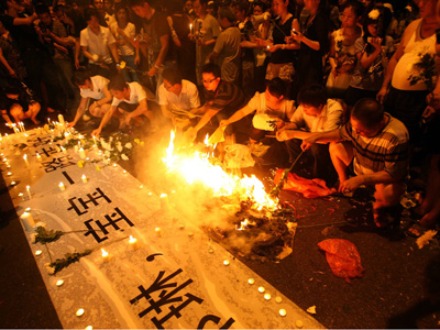 Local residents in Nanjing, Jiangsu province, gathered at the roadside to mourn Zheng Lin who was among five people killed on June 30 by a drunk driver, on Monday, July 6, 2009. [Photo: Xinhua]