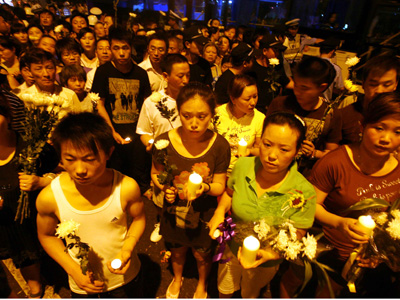 Local residents in Nanjing, Jiangsu province, gathered at the roadside to mourn Zheng Lin who was among five people killed on June 30 by a drunk driver, on Monday, July 6, 2009. [Photo: Xinhua]