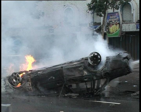 Photo released by police shows a car burned and overturned by rioters in Urumqi, capital of northwest China's Xinjiang Uygur Autonomous Region on July 5, 2009. [chinadaily.com.cn] 