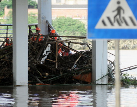 Local cleaners tidy up silt and rubbish after floods hit Liuzhou in southwest Guangxi Zhuang autonomous region on July 6, 2009.[Xinhua] 