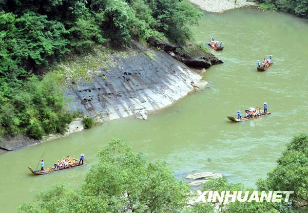 Tourists are seen drifting along Jiuqu stream in a photo issued on July 6, 2009. Dawang Mountain is a part of the Wuyi Mountain scenic area in Fujian Province, which has been listed as a world natural and cultural heritage site. It also includes Shennv Mountain and Jiuqu stream. The scenic area receives more than 10,000 tourists a day during the summer. [Photo: Xinhuanet.com]