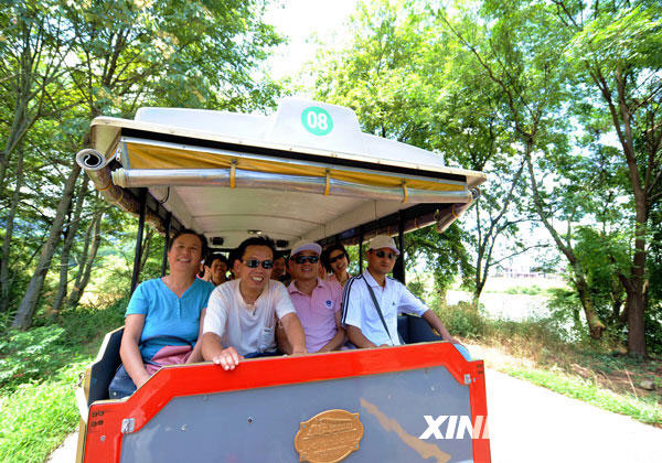 Tourists are on an environmental sightseeing around Wuyi Mountain scenic area, shown in a photo issued on July 6, 2009. Dawang Mountain is a part of the Wuyi Mountain scenic area in Fujian Province, which has been listed as a world natural and cultural heritage site. It also includes Shennv Mountain and the Jiuqu stream. The scenic area receives more than 10,000 tourists a day during the summer. [Photo: Xinhuanet.com]