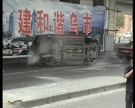 Photo released by police shows a car smashed and overturned by rioters in Urumqi, capital of northwest China&apos;s Xinjiang Uygur Autonomous Region on July 5, 2009. [chinadaily.com.cn]