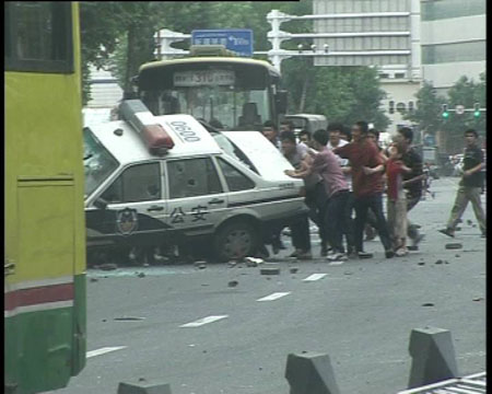 Photo released by police shows rioters smash and overturn a police car in Urumqi, capital of northwest China&apos;s Xinjiang Uygur Autonomous Region on July 5, 2009. [chinadaily.com.cn]