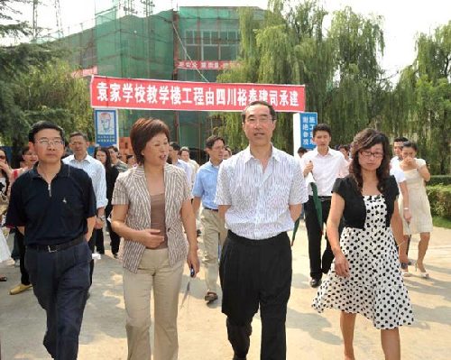 Henry Tang, second from right, is briefed on the construction progress of a primary school in Deyang, in Sichuan Province on July 5th, 2009. [Photo courtesy of the Hong Kong SAR Government]