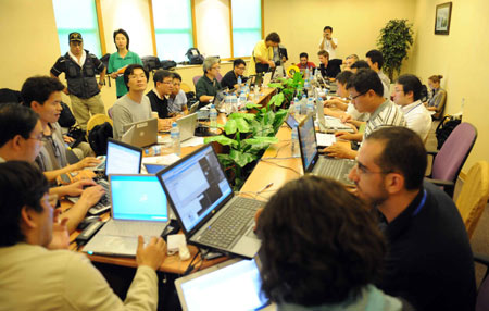 Chinese and foreign journalists work at the press center established at Hoi Tak Hotel in Urumqi, capital of northwest China's Xinjiang Uygur Autonomous Region, July 7, 2009. More than 60 overseas media have sent journalists to Urumqi after a riot broke out in the city Sunday, leaving 156 people dead and 1,080 others injured. (Xinhua/Sadat)