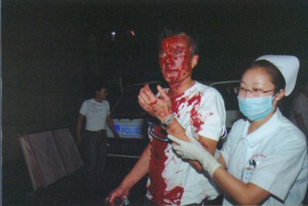 File photo released by the government of Urumqi City in a press conference in Urumqi, capital of northwest China's Xinjiang Uygur Autonomous Region, on July 7, 2009, shows a medical worker taking care of a man injured in the riot.[Xinhua]