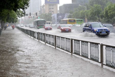 Vehicles struggle on the flooded road in Nanjing, capital of east China's Jiangsu Province, July 7, 2009. A heavy downpour drenched the city and blocked the traffic from Monday night to Tuesday morning. [Sun Can/Xinhua]