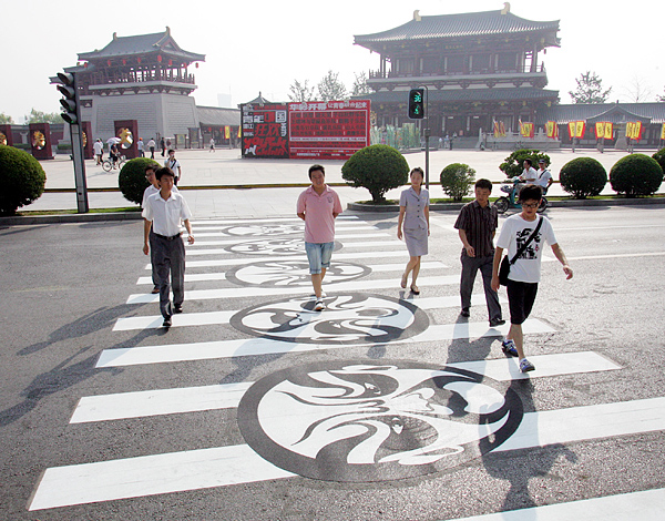 On July 7 people walk across the street on a zebra crossing featuring Shaanxi opera masks and shadow puppet imagery. The zebra crossings are located in a residential area in Qujiang District, Xi'an. Shaanxi opera and shadow puppetry are typical Shaanxi local art forms. Shaanxi Opera is one of the oldest forms of opera in China and its masks have had a great influence on the facial make-up of Peking Opera. [Photo:Xinhuanet]