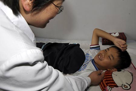 A doctor carries out the psychological intervention treatment for a boy who was injured in the deadly July 5 riot at a hospital in Urumqi, capital of northwest China's Xinjiang Uygur Autonomous Region, July 7, 2009. (Xinhua/Zhao Ge)