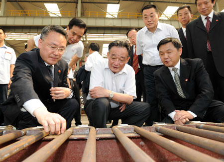 Wu Bangguo (C), a member of the Standing Committee of the Communist Party of China Central Committee Political Bureau and chairman of the Standing Committee of the National People's Congress, visits a plant of Anhui's Conch Group in east China's Anhui Province, July 3, 2009. Wu Bangguo paid a visit to Anhui between July 2 and 7.