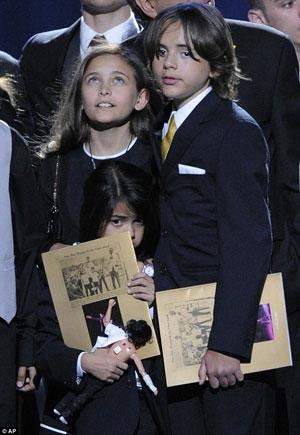 Missing daddy: Paris (L) and Prince Michael Jackson I (R) watch the crowd while Their brother Prince Michael Jackson II hides between them