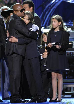 Randy Jackson (L) embraces Prince Michael Jackson I, with Paris Jackson (R) and Prince Michael II (2nd R) looking on, during the memorial service for Michael Jackson at the Staples Center in Los Angeles July 7, 2009.