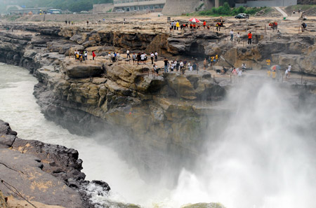 Visitors view and admire the limpid Hukou Waterfall on the Yellow River at Jixian County, north China's Shanxi Province, July 7, 2009. [Yan Ruipeng/Xinhua]