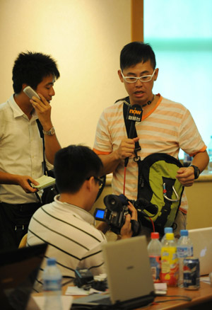 Journalists from south China's Hong Kong work in Urumqi, capital of northwest China's Xinjiang Uygur Autonomous Region, July 8, 2009. [Xu Liang/Xinhua] 