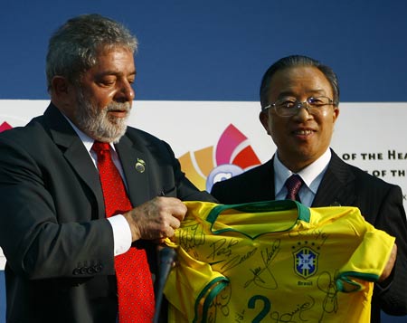  Chinese State Councilor Dai Bingguo (R) receives a uniform of the Brazilian national football team presented by Brazilian President Luiz Inacio Lula da Silva (L) after a press conference in L'Aquila, Italy, July 8, 2009. On behalf of Chinese President Hu Jintao, State Councilor Dai Bingguo attended a joint press conference with leaders of India, Brazil, South Africa and Mexico here on Wednesday. [Zhang Yuwei/Xinhua]