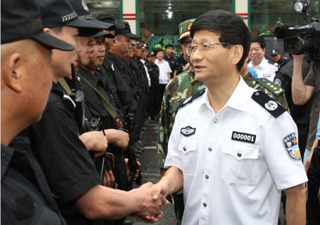 Meng Jianzhu (R), China's state councilor and public security minister, visits policemen in Urumqi, capital of northwest China's Xinjiang Uygur Autonomous Region, July 8, 2009.