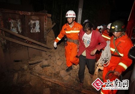 Firefighters rescue a woman after a magnitude-6.0 earthquake hit Yao'an county, Yunnan province, July 9, 2009.[Xinhua]
