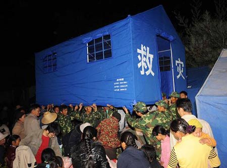 Soldiers pitch tents for the quake-afflicted people. More than 300 people were injured and more than 10,000 houses collapsed in a 6.0-magnitude earthquake that hit southwest China's Yunnan Province Thursday evening, local authorities said. [Xinhua]