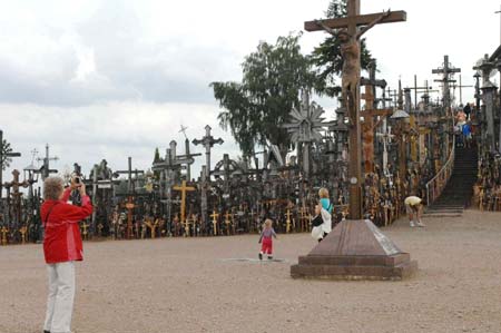 A tourist takes a photo of a cross of the Hill of Crosses, a dozen kilometres outside the city of Siauliai, Lithuania, July 8, 2009. There are now about 200,000 crosses on the hill. [Xinhua]