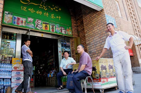 People rest at a shop in business in the Erdaoqiao area in Urumqi, capital of northwest China's Xinjiang Uygur Autonomous Region, July 9, 2009. Shopping malls, supermarkets, agricultural product markets and gas stations are resuming business in the riot-torn Urumqi. [Xinhua]
