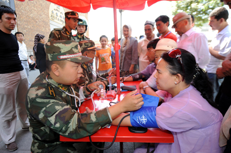 Residents consult a medical member of the Armed Police during a community free medical service at a street in Urumqi, capital of northwest China&apos;s Xinjiang Uygur Autonomous Region July 9, 2009.