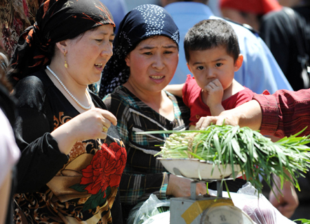 Residents buy vegetables at the Erdaoqiao market in Urumqi, capital of northwest China&apos;s Xinjiang Uygur Autonomous Region July 9, 2009. The local business administration distributed tens of railway wagons of vegetables to fully supply the city on Thursday.
