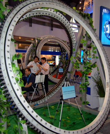 Visitors talk about an equipment on display during the 6th Asian Wind Energy Exhibition in Beijing, capital of China, on July 8, 2009. The exhibition, attended by 445 enterprises from 22 countries and regions, kicked off here Wednesday. [Gong Lei/Xinhua]