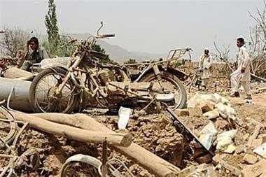 Afghan men ìnspect the site of an explosion in Mohammad Agha district of Lohar province, about 30 kms south of the capital Kabul. A truck rigged with explosives blew up near Kabul on Thursday killing 25 people including many students in one of the deadliest blasts in Afghanistan this year, police said.[Shah Marai/CCTV/AFP]