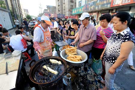 Residents buy food for breakfast at a market in Urumqi, capital of northwest China's Xinjiang Uygur Autonomous Region, on the morning of July 10, 2009.[Xinhua]