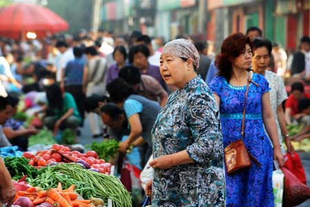 Residents buy vegetables at a market in Urumqi, capital of northwest China's Xinjiang Uygur Autonomous Region, on the morning of July 10, 2009. [Xinhua]