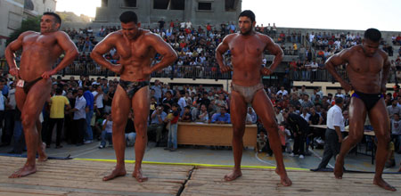 Palestinian bodybuilders display their skills in a locally organaized competition in al-Nussierat refugee camp, central Gaza Strip, on July 10, 2009. [Wissam Nassar/Xinhua] 