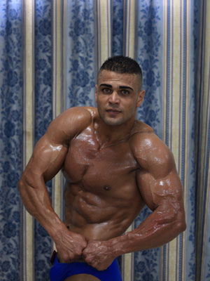 A Palestinian bodybuilder displays his skills in a locally organaized competition in al-Nussierat refugee camp, central Gaza Strip, on July 10, 2009. [Wissam Nassar/Xinhua] 